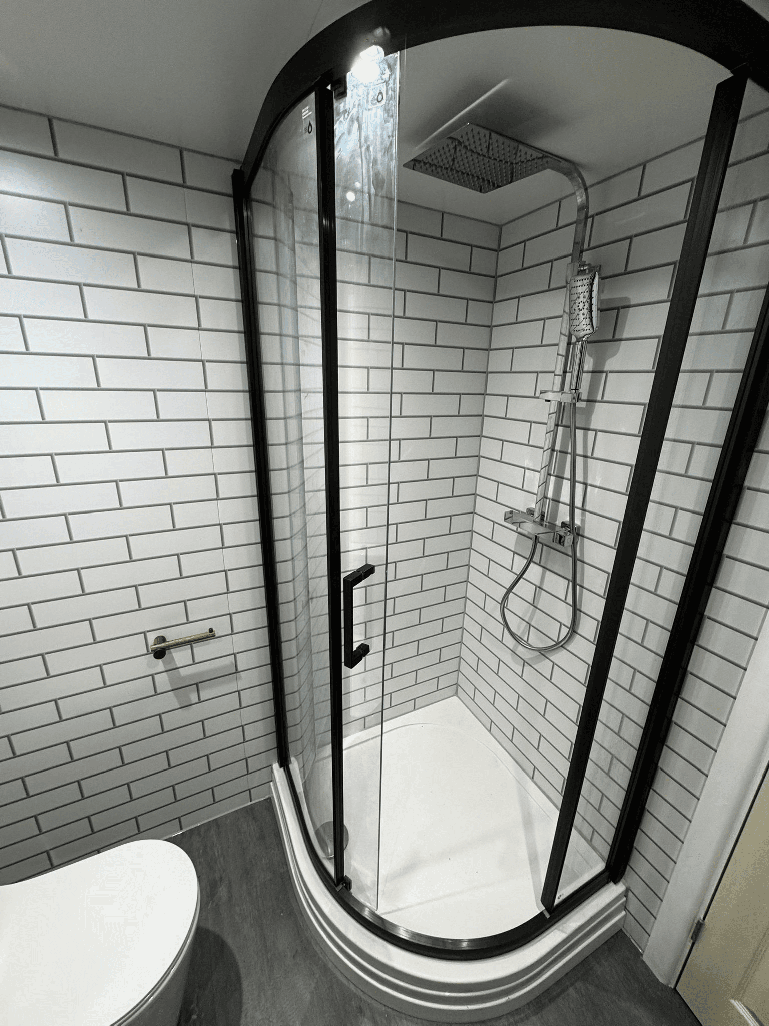 Black shower enclosure with white subway tiles