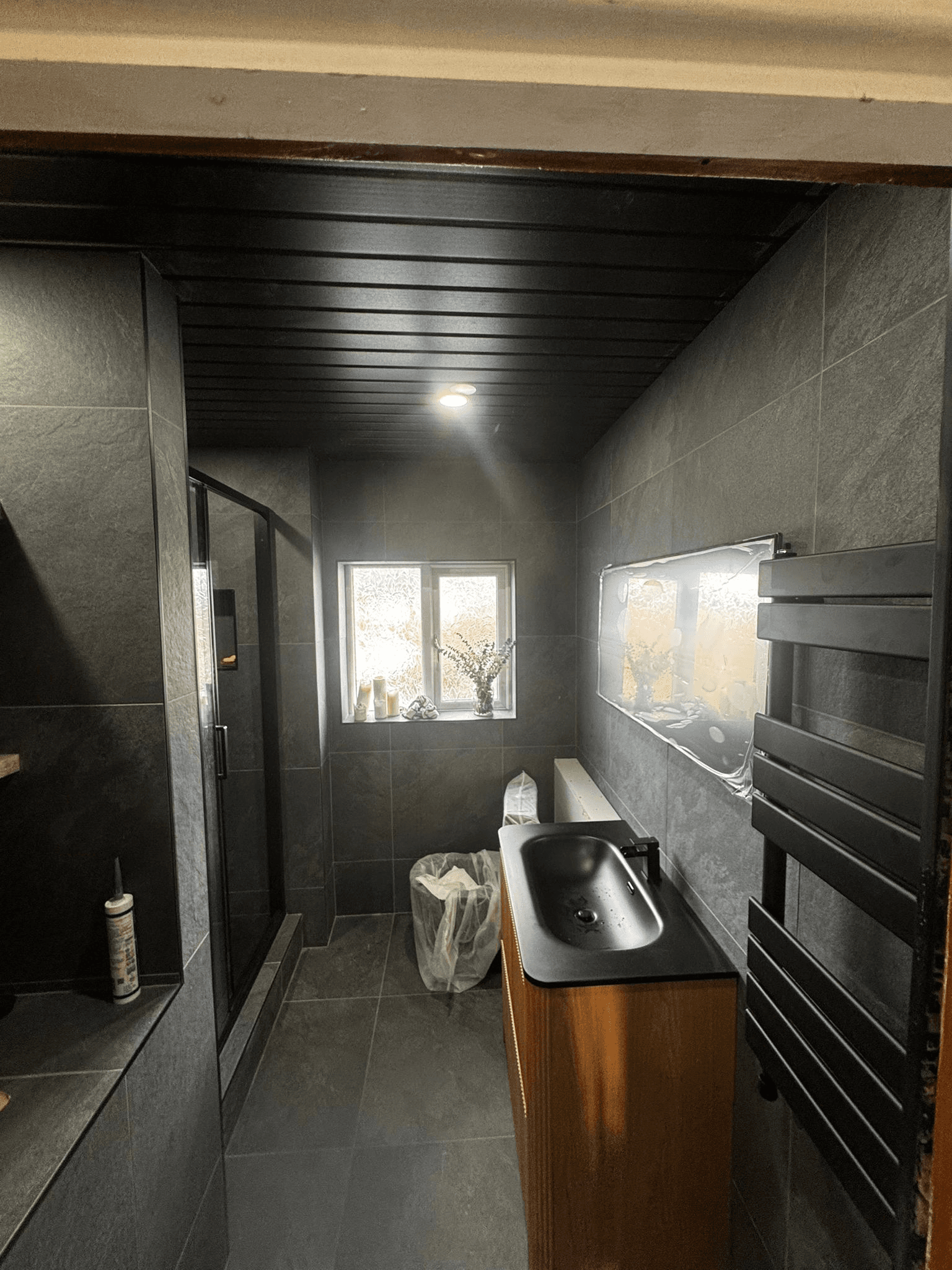 Dark luxury bathroom with black sink and slate tiles