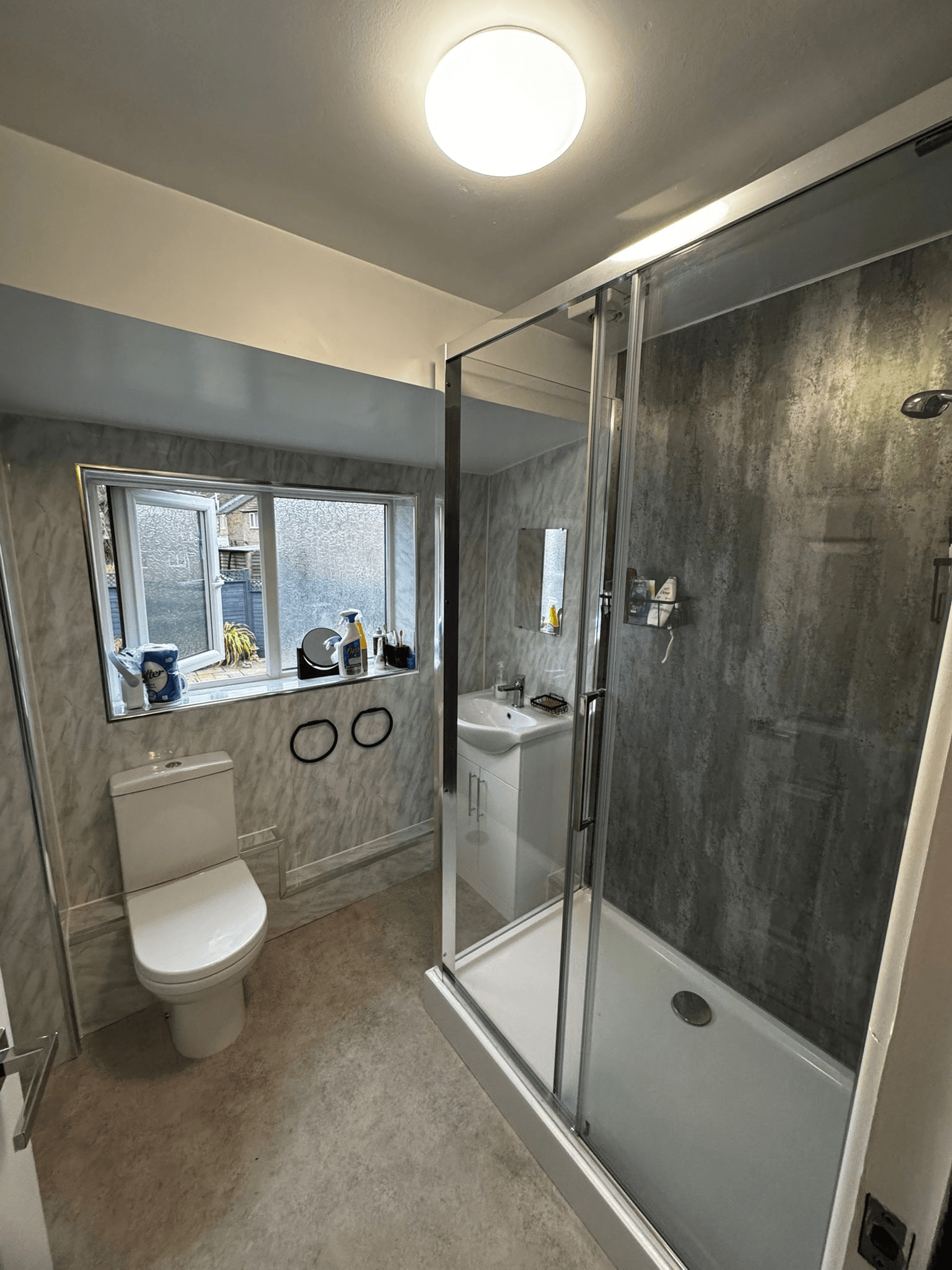Grey tiled bathroom with shower enclosure