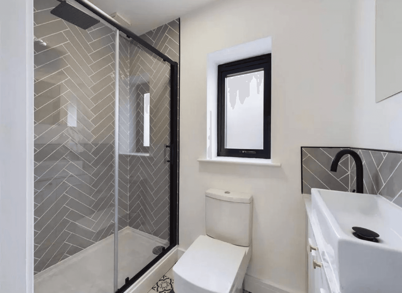 Bathroom with herringbone tiles and black shower enclosure