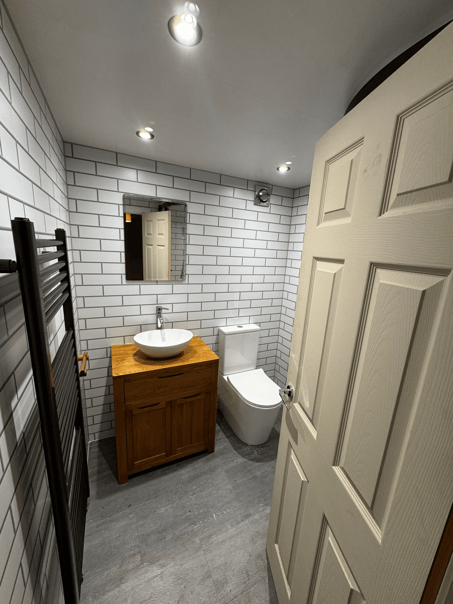 Bathroom with white subway tiles and wooden vanity unit
