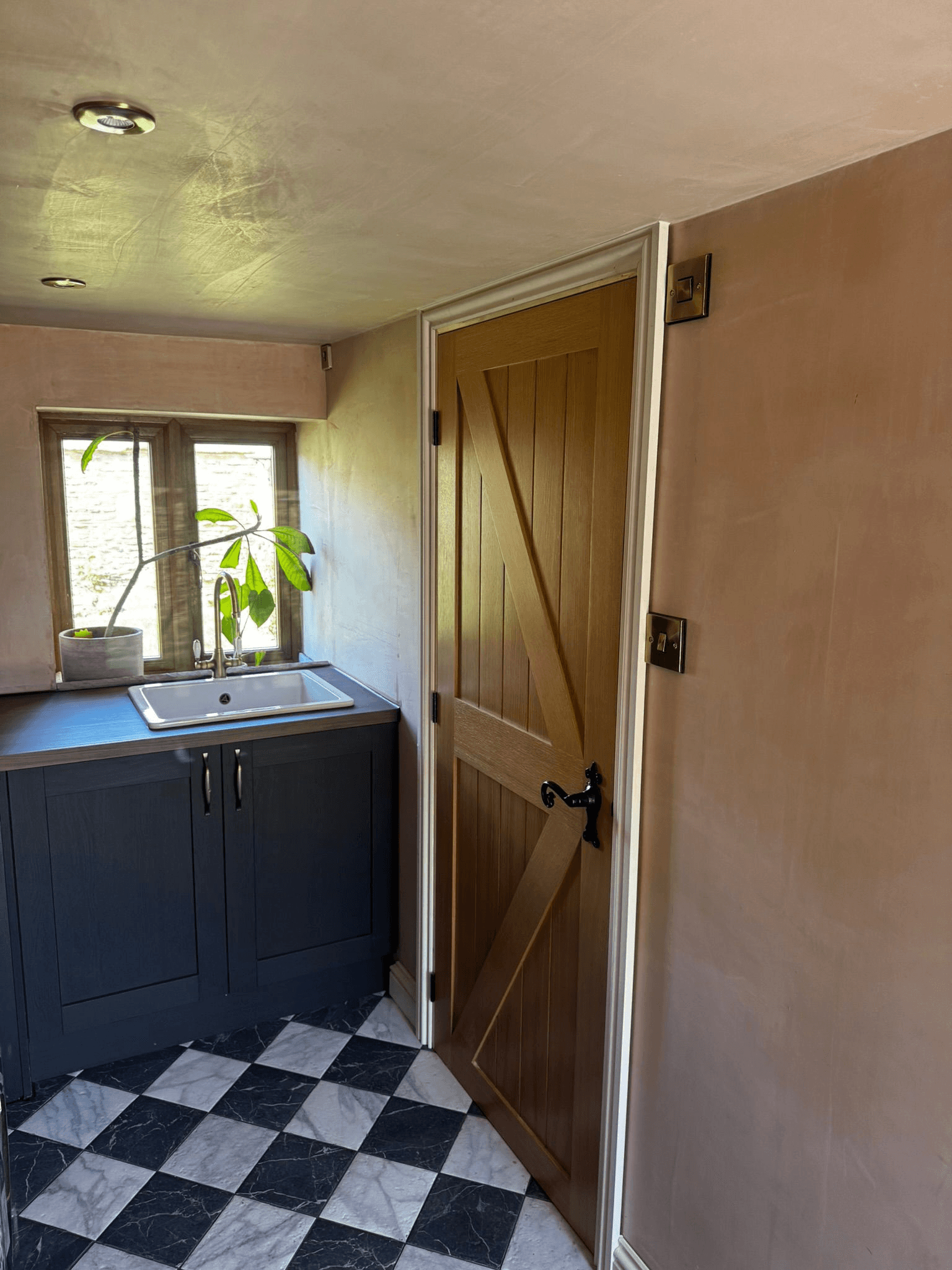 Utility room with dark cabinets and checkered floor tiles